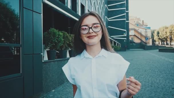 Una chica en el distrito de negocios de la ciudad va a una reunión de socios de negocios. Mujer joven con ropa de negocios. Estilo de negocio . — Vídeo de stock