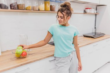 Mutfak mutlu genç kadın yeme elma. Diyet. Diyet kavramı. Sağlıklı gıda. Ağırlık kaybetme