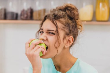 Mutfak mutlu genç kadın yeme elma. Diyet. Diyet kavramı. Sağlıklı gıda.