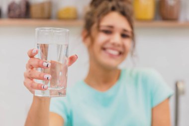 Taze su tutarak ve gülümseyen güzel, güzel, genç kadını