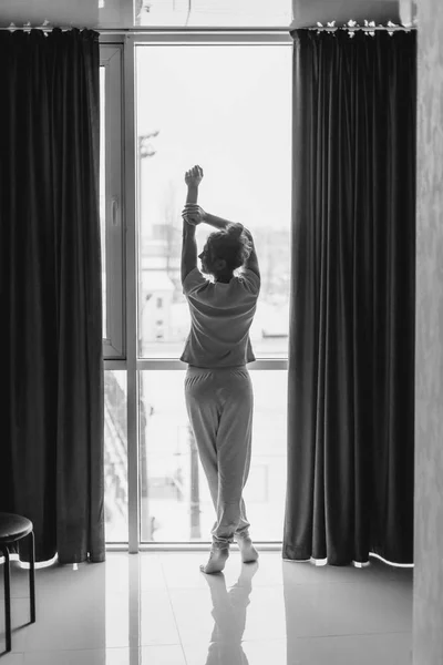 아침에 여자는 일출 모습과 그녀의 집에 창에 의해 서. 깨어나. — 스톡 사진
