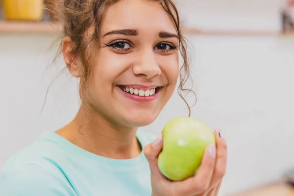 Mujer joven feliz comiendo manzana en la cocina. Dieta. Concepto de dieta. Alimento saludable . — Foto de Stock