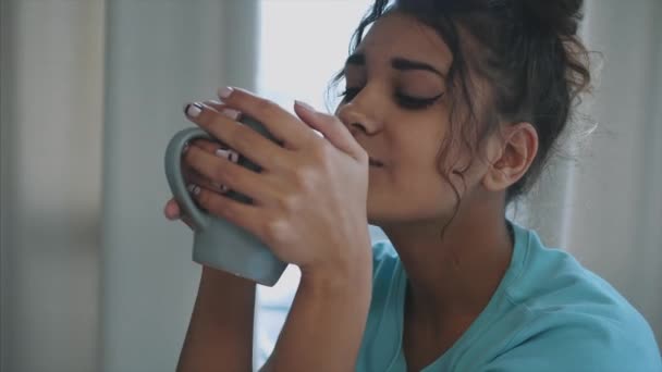 Великолепная, красивая, молодая женщина, держащая стакан пресной воды и улыбающаяся, стоя утром на кухне — стоковое видео