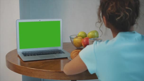 Coupé instantané des mains féminines avec des tasses jetables de café et de croissants. Ordinateur portable et accessoires sur la table . — Video