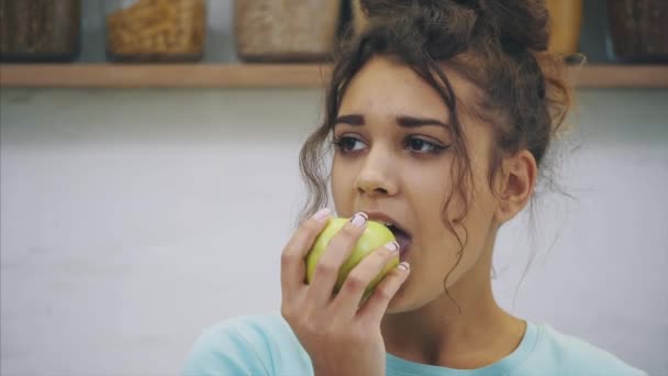 Giovane donna felice che mangia mela in cucina. Dieta. Il concetto di dieta. Cibo sano. Pesata allentata . — Video Stock