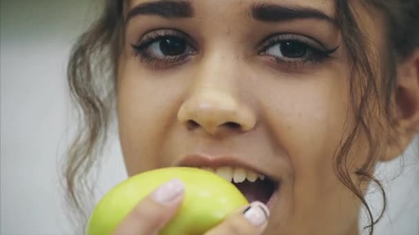Glückliche junge Frau beim Apfel essen in der Küche. Ernährung. Diätkonzept. Gesunde Ernährung. Gewicht verlieren. — Stockvideo