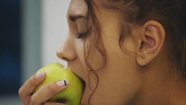 キッチンで幸せな若い女食用リンゴ。ダイエット。ダイエットのコンセプトです。健康食品。重量を失う. — ストック動画