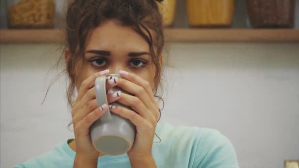 Magnifique, belle, jeune femme tenant un verre d'eau douce et souriant tout en restant debout dans la cuisine le matin — Video