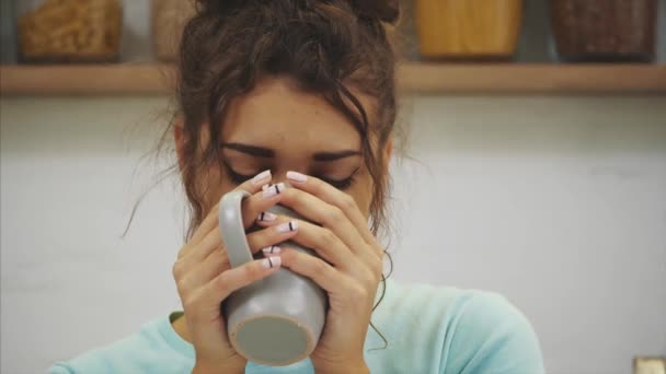 Magnifique, belle, jeune femme tenant un verre d'eau douce et souriant tout en restant debout dans la cuisine le matin — Video