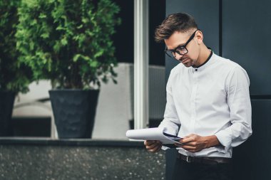 bir şehir sokak üzerinde duran işadamı okuma makaleler