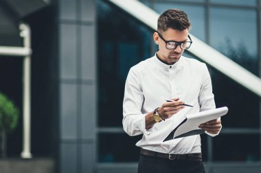 bir şehir sokak üzerinde duran işadamı okuma makaleler