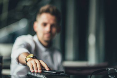 Adamın telefonu masanın üstüne koy. telefon üzerinde odaklanmak