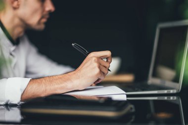 Planı yapma. Dizüstü bilgisayar kullanarak ve bazı notlar memnun adam portresi. seçici odak