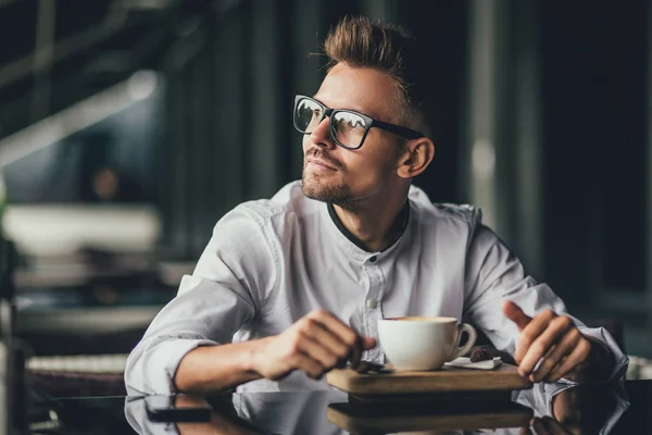Tankeväckande stilig affärsman dricka kaffe i caféet och titta bort — Stockfoto