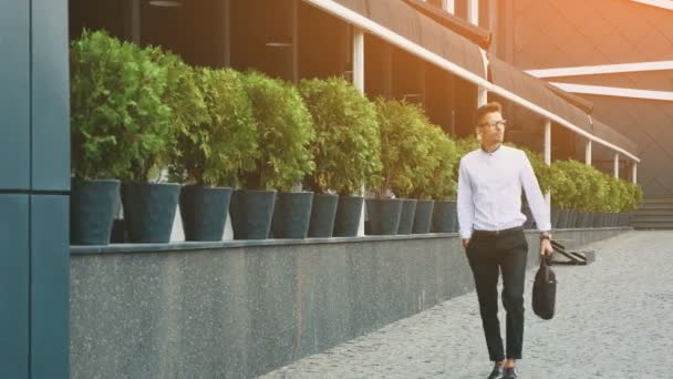 Jeune homme d'affaires vêtu de vêtements de travail va au travail . — Video