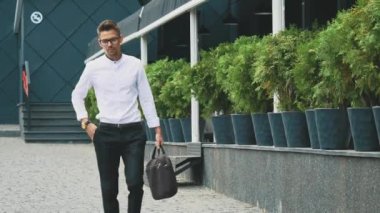 İş elbiseleri giymiş genç iş adamı işe gider.