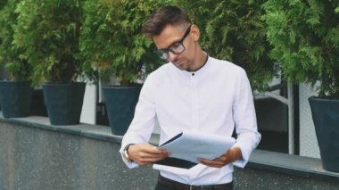 Ofiste iş giyim ve gözlük standları giymiş genç iş adamı.