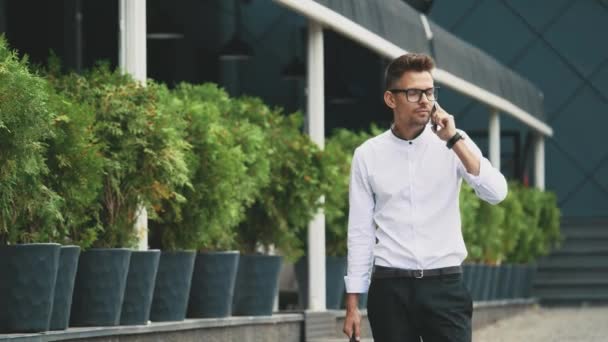 Joven hombre de negocios vestido con ropa de negocios va a trabajar . — Vídeos de Stock