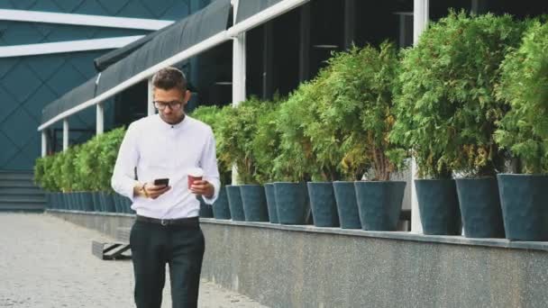 Joven hombre de negocios vestido con ropa de negocios y gafas va a trabajar . — Vídeos de Stock