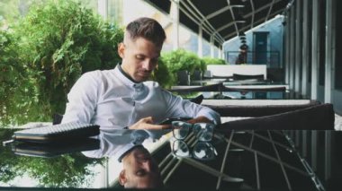 İş elbiseleri ve gözlük ofiste oturan genç işadamı giymiş.