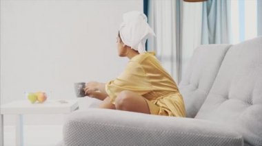 Bir Tv kanalı bir banyodan sonra geri kalan döneminde seçme mutlu kadın bir uzaktan kumanda ile.
