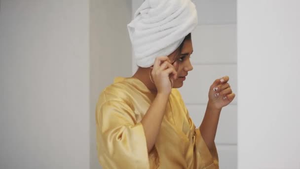 Close-up portrait of attractive Caucasian smiling woman brunette. Fixes hair under the towel. — Stock Video