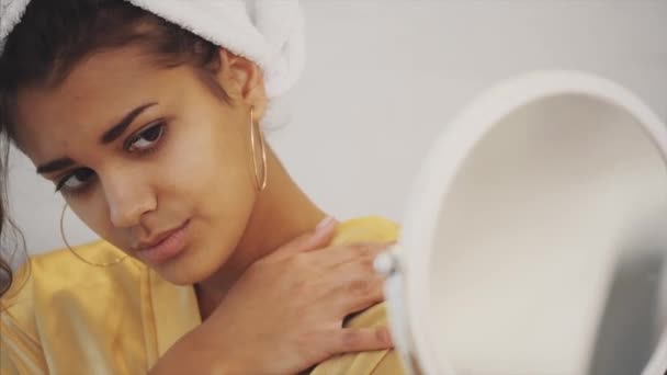 Une beauté tranquille. Portrait d'une jeune femme calme debout devant le miroir et massant ses joues. Elle est charmante et concentrée . — Video