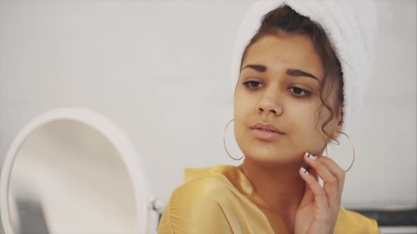 Beleza silenciosa. Retrato de uma jovem calma de pé na frente do espelho e fazendo massagem nas bochechas. Ela é encantadora e focada . — Vídeo de Stock