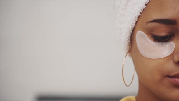후에 머리에 수건 목욕 박 패치 눈 밑 주름과 다크 서클에서 아름 다운 여자의 근접 촬영 초상화. — 비디오