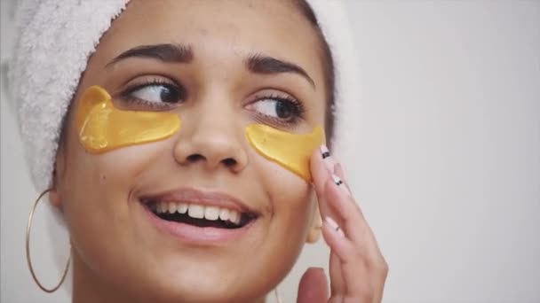 Un ritratto primo piano di una bella donna dopo un bagno con un asciugamano sulla testa mette macchie sotto gli occhi da rughe e occhiaie. . — Video Stock