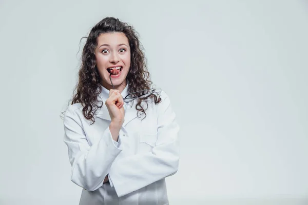 Belle femme souriante - le médecin qui regarde la caméra la moitié du tour. Femme heureuse et drôle portant un portrait médical avant sur un fond gris. Concepts médicaux . — Photo