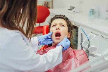 Bir diş hekimi resepsiyonunda kızdır. Mutlu müşteri, diş hekimi gülümsüyor. Diş beyazlatma. Diş Kliniği. Modern kliniğinde diş tedavisi.