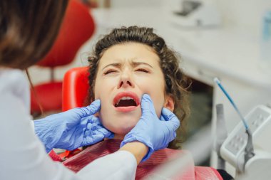 Bir diş hekimi resepsiyonunda kızdır. Mutlu müşteri, diş hekimi gülümsüyor. Diş beyazlatma. Diş Kliniği. Modern kliniğinde diş tedavisi.