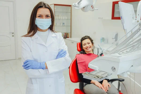 Dentysta i pacjenta. Młody piękny dentysta naprawy zęby piękne Młoda kobieta w biurze Dentyści. Dentysta, noszenie chirurgiczne rękawice biały uniform i maski. — Zdjęcie stockowe