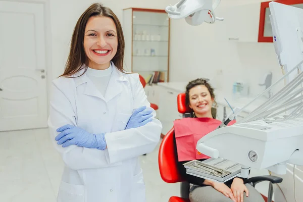 Genç bir kadın ile bir hasta x-ışını diş dişçi ofisinde gösterilen bir dişçi. Konuların tartışılması. Profesyonel bir diş hekimi görüntüsünü kırpılmış. — Stok fotoğraf
