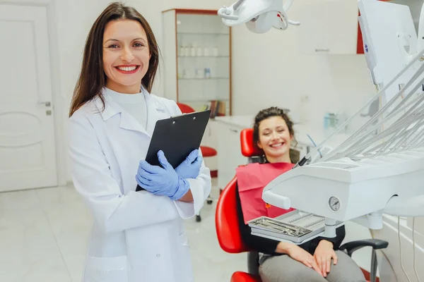 Un dentista, mostrando a una mujer joven con un diente de rayos X de pacientes en el consultorio del dentista. Debate de temas. Imagen recortada de un dentista profesional . — Foto de Stock