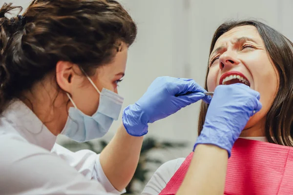 De dokter doet professioneel. Glimlachend mooi meisje met haar witte tanden, onderzocht door een tandarts in de kliniek. — Stockfoto