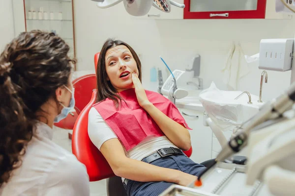Üzücü bir genç kızın acı bir diş, Ofis koltukları bir doktor, bir izole dişçi office arka plan Kliniği ile yakın çekim portre. E