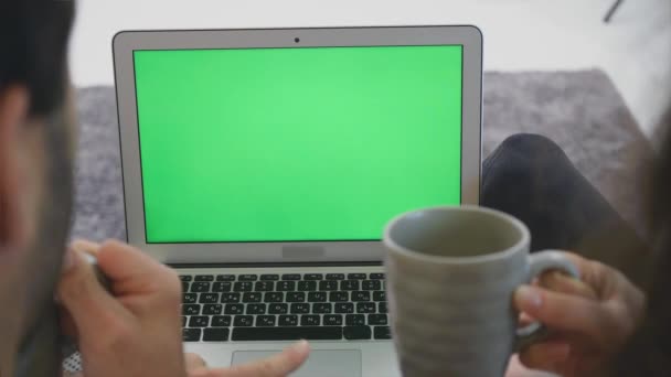 Wir lieben die junge Familie zusammen. schönes junges Paar. Liebevolle Beziehung zueinander und lächelnd auf einen Laptop schauen, während man gemeinsam auf der Couch sitzt. — Stockvideo