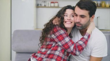 Genç çift kendi dairesinde rahatlatıcı, kanepede oturan, TV izlerken. aşıklar ve mutlu sarılmak.