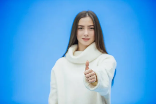 Portrait of a young girl business. High girl on a blue background. During this time she is dressed in a white warm sweater. — Stock Photo, Image