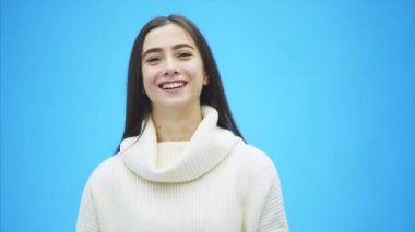 Genç enerjik kız mavi bir arka plan üzerinde duruyor. Bu gülümseme sırasında saç ayarlanabilir.