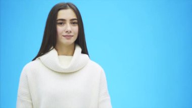 Genç güzel kız beyaz elbise giymiş. Bu süre içinde bu mavi bir arka plan üzerinde duruyor. Bir kelime aşk elinde tutan.