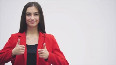 Güzel bir genç esmer portresi. Kameraya bak. Bu sırasında o kadar bir jest sınıf iki elle gösterilen kollarını kaldırdı. Kırmızı bir ceket giymiş.
