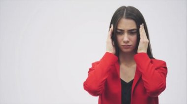 Güzel bir genç esmer gri bir arka plan üzerinde stres hissediyor onun tapınaklar dokunmadan Açık omuz ile portresi.