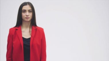 Güzel bir genç esmer portresi. Kameraya bak. Bu sırasında elini kaldırdı ve bir jest para göstermeye başladı. Kırmızı bir ceket giymiş.