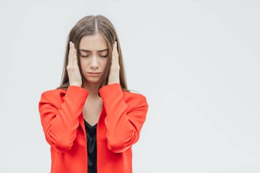 Güzel bir genç esmer gri bir arka plan üzerinde stres hissediyor onun tapınaklar dokunmadan Açık omuz ile portresi.