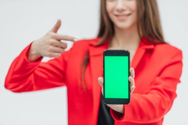 Genç, güzel ve ciddi bir kız bulanık bir alanda kırmızı bir ceket giymiş. Gri bir arka plan üzerinde kalır. Bu süre boyunca, siyah bir telefon bir eliyle tutarak Öte yandan bir işaret parmağı üzerinde gösterir