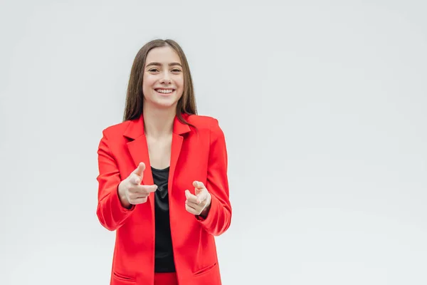 Young good girl business is worth it. Shows with two hands forward. During this, the index finger shows directly. Dressed in a red jacket. — Stock Photo, Image