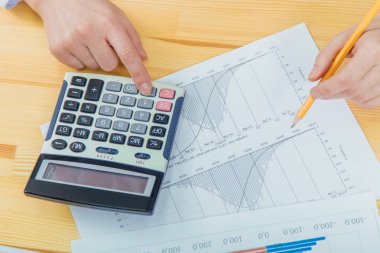 Finansal veri sayma analizi için hesap makinesi ile yatırım grafikleri analiz işkadını.